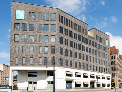 En byggnad som består av vit färg nedtill och annan typ av fasad ovantill. 